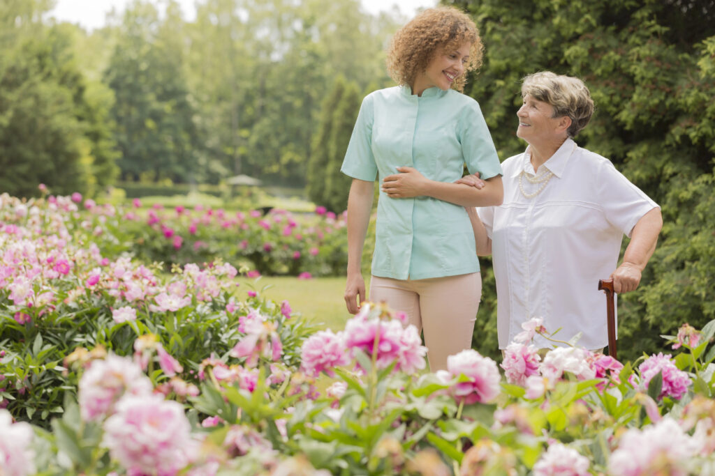 A Missoula caregiver walking her client through a flower garden